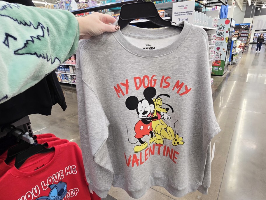 hand holding up a sweatshirt that says My Dog Is My Valentine