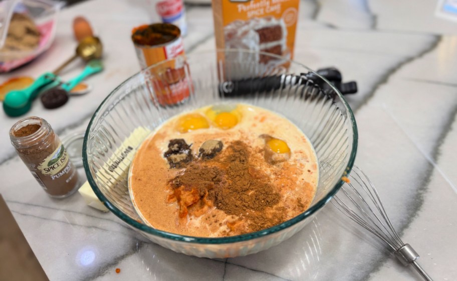 mixing pumpkin dump cake ingredients in a bowl 