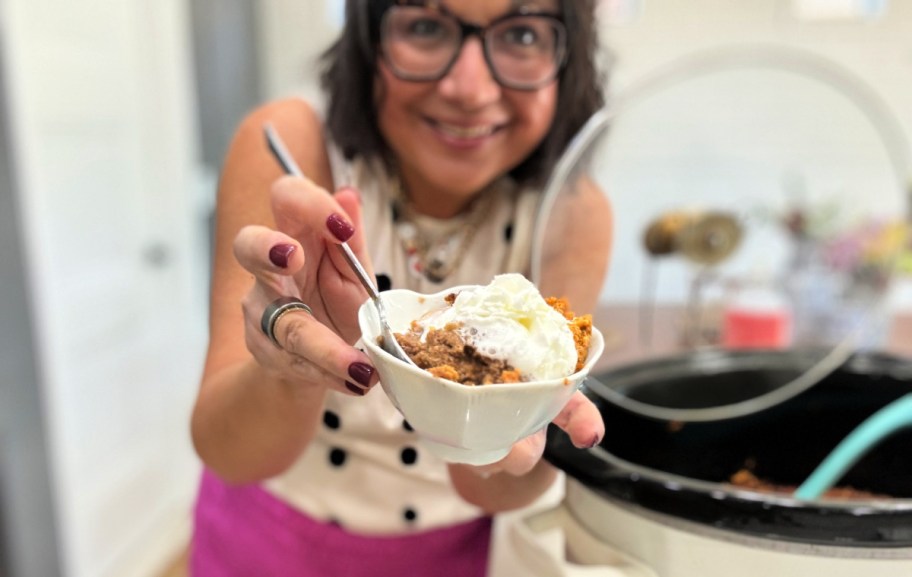 woman holding a bowl with pumpkin dump cake (