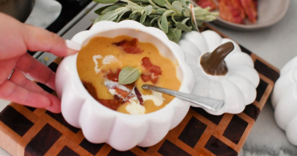 holding a bowl of butternut squash soup
