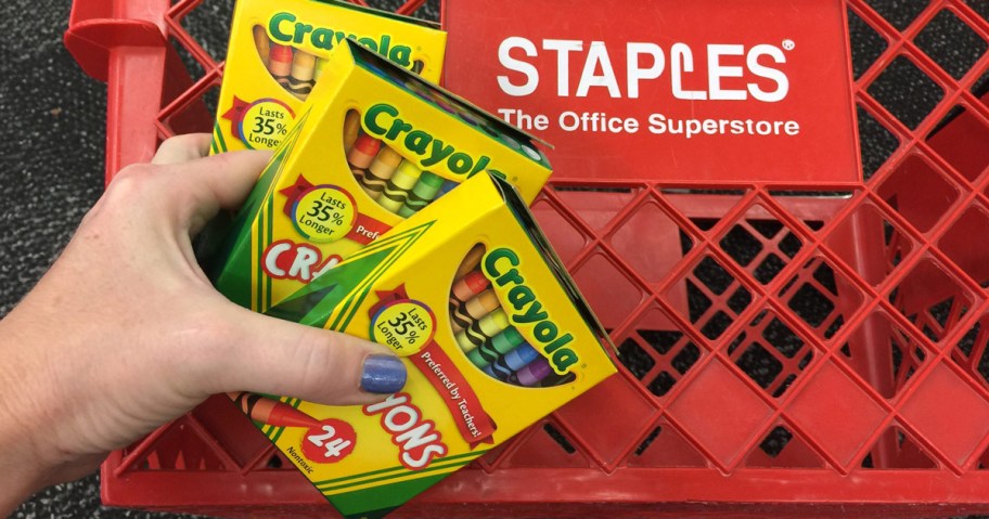 boxes of crayons held over a red staples basket