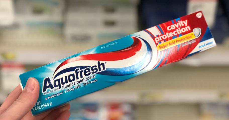 hand holding Aquafresh cavity protection toothpaste box