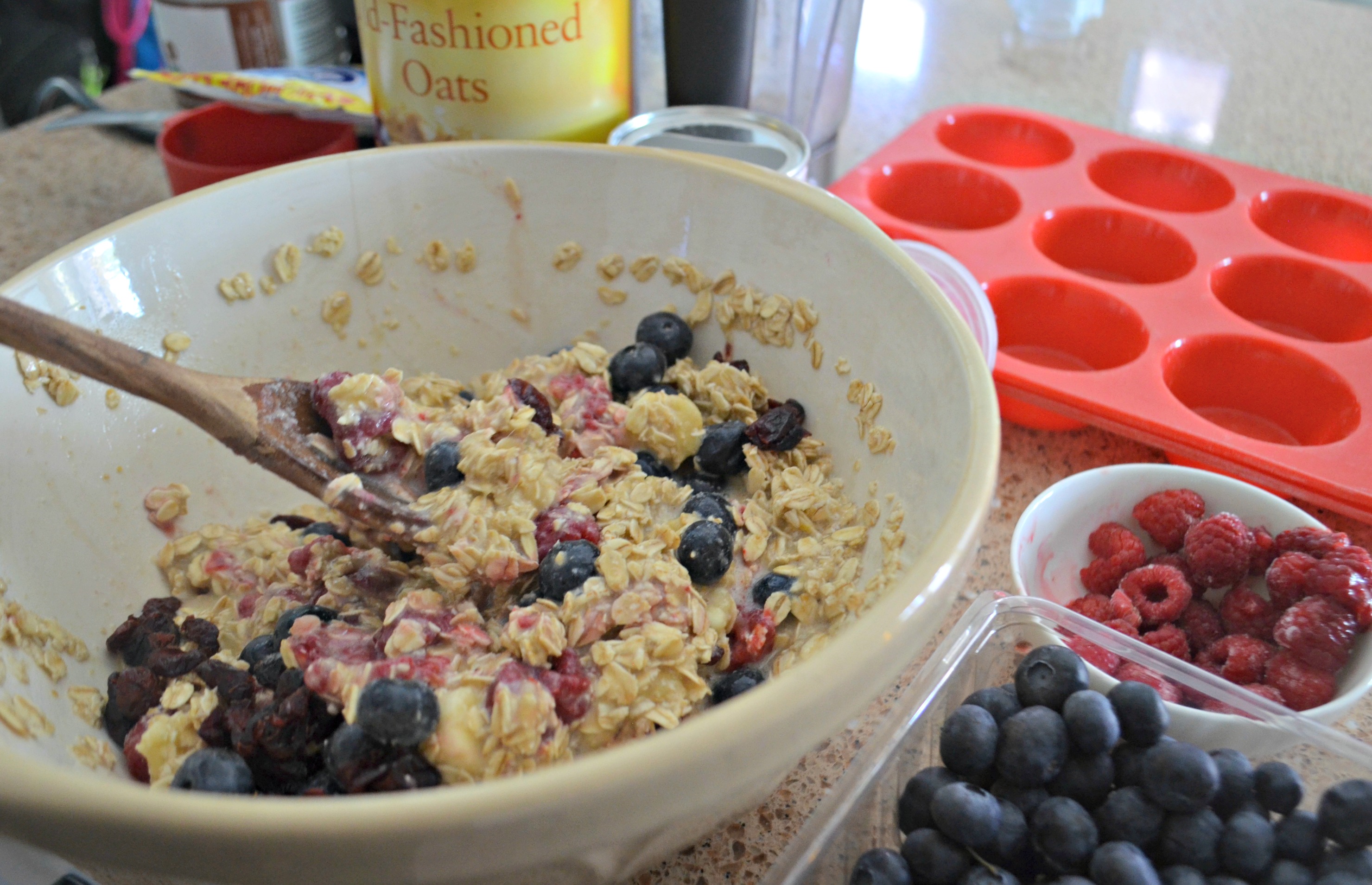 Baked Oatmeal Berry Cups &ndash; mixing the ingredients in a bowl with a wooden spoon