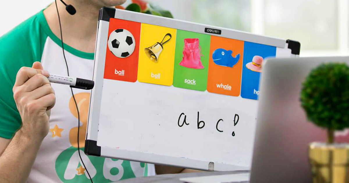Teacher holding up a whiteboard to earn money teaching English at home with SayABC.com. 