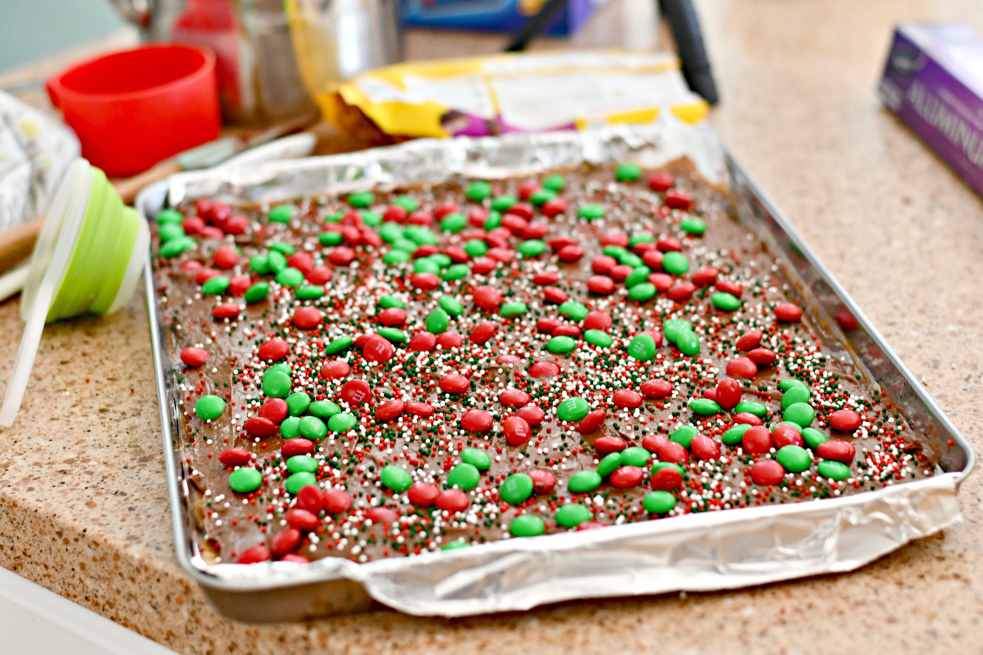 homemade christmas crack toffee &ndash; after adding M&M candies and sprinkles in the pan