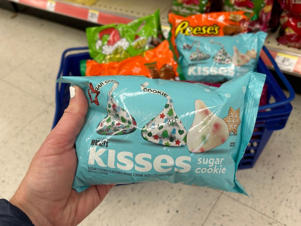 person holding a bag of holiday themed Hershey kisses inside Walgreen store
