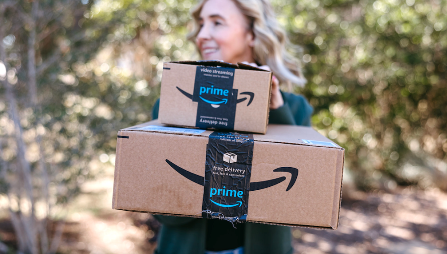 woman posing behind stacked amazon boxes
