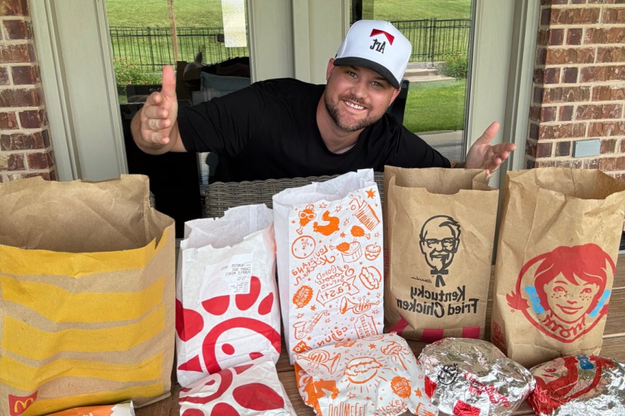 man in front of chicken sandwich fast food bags
