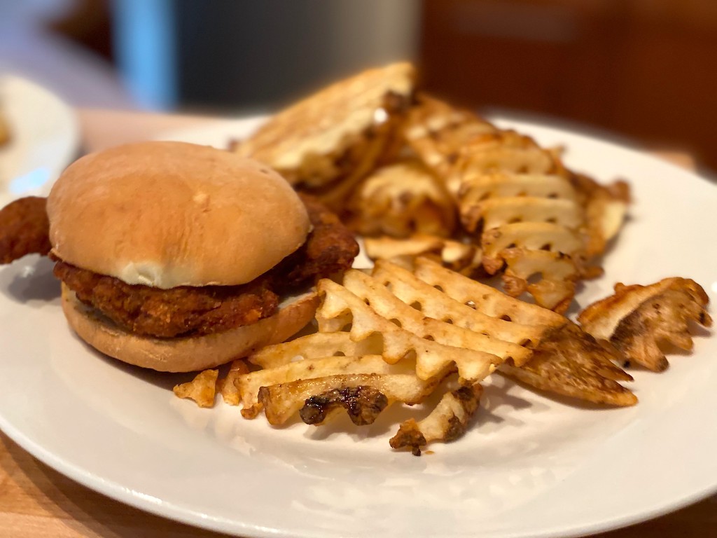 chicken sandwich on plate with waffle fries