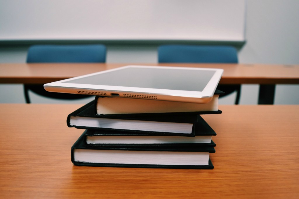 stack of textbooks and ipad in classroom