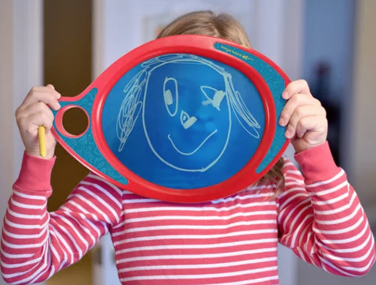kid holding electronic board with face drawing on screen