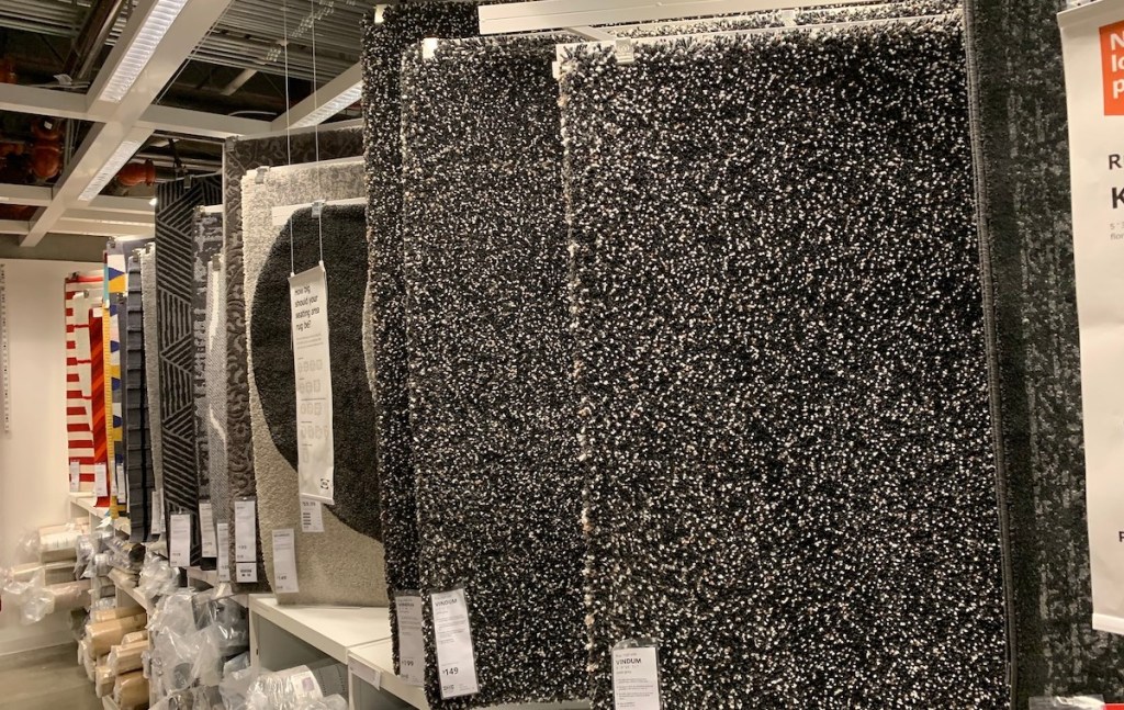 row of various rugs hanging at IKEA store 