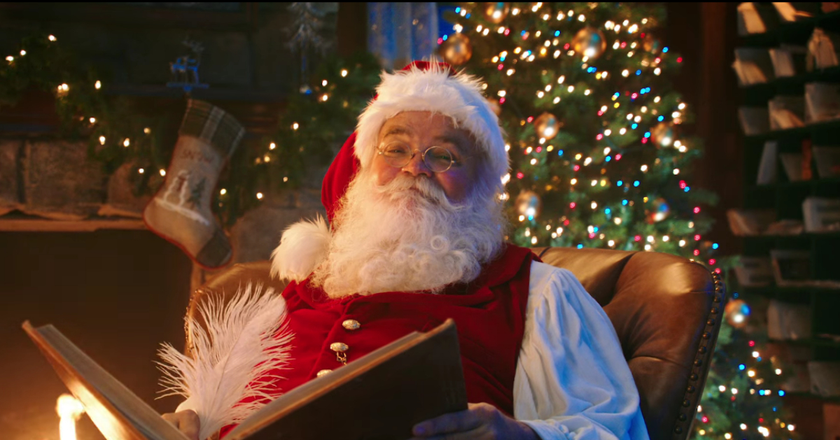 Santa Claus in a chair holding a book