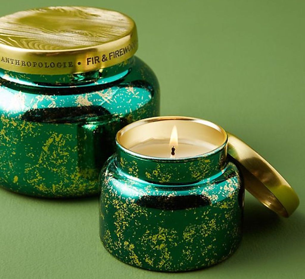 Capri Blue Fir & Firewood Jar Candle on green background with one candle lit