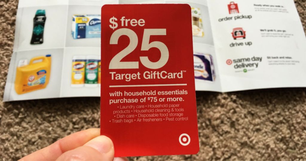 hand holding Target Household essentials coupon with flyer in the background