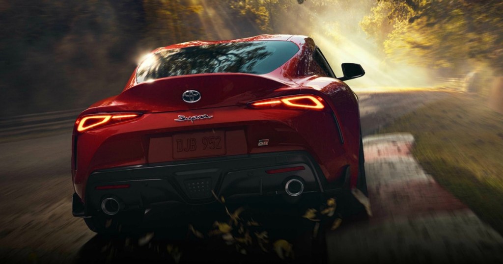 red Toyota Supra GR sports car being driven down a road