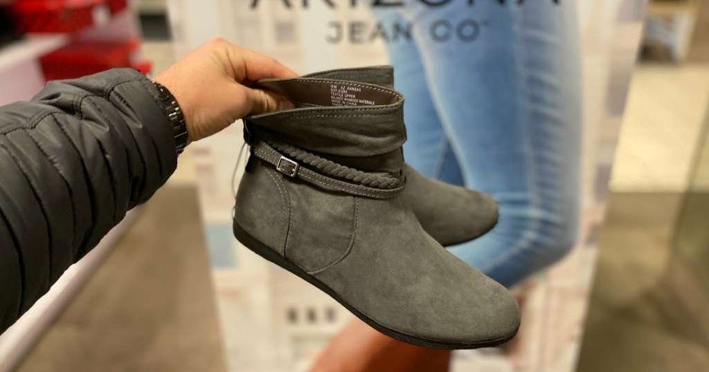 man holding up a pair of Arizona boots