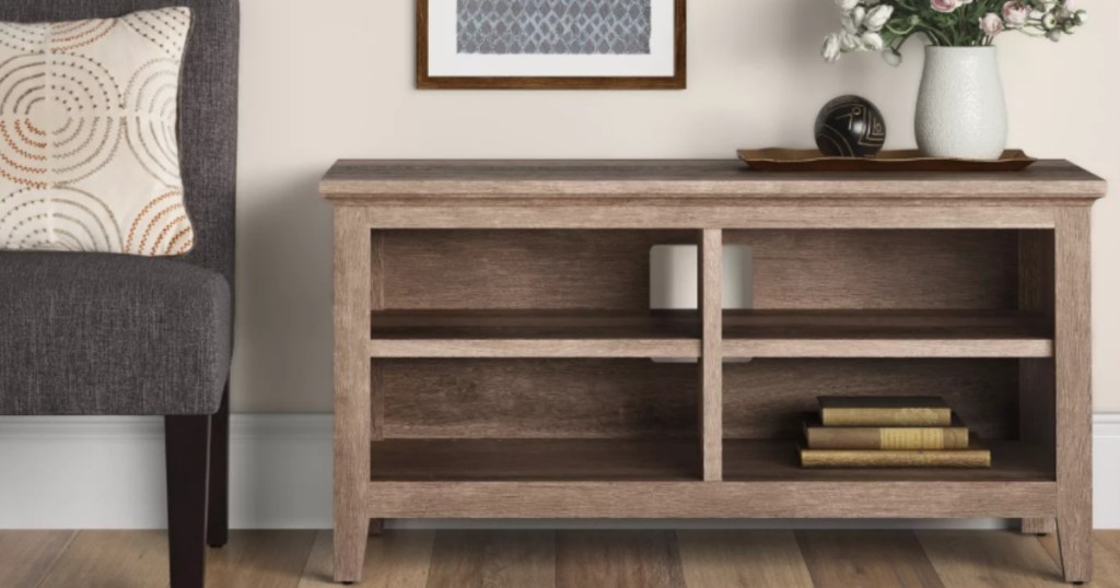 light brown rustic media console nest to an armchair