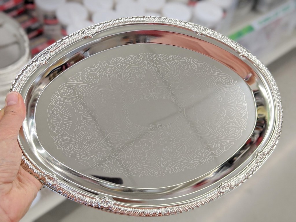 hand holding a silver serving tray