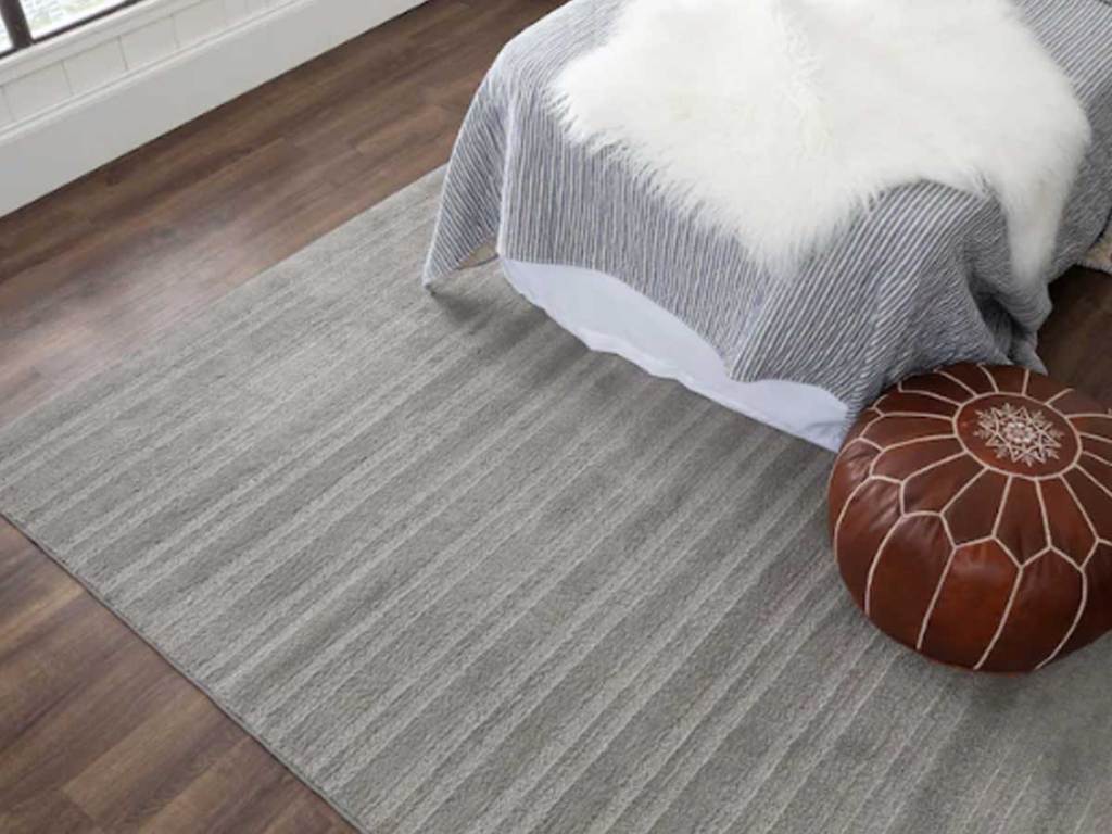 striped area rug on floor in bedroom