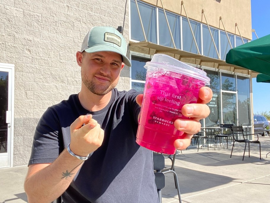 man holding pink Starbucks Refresher drink