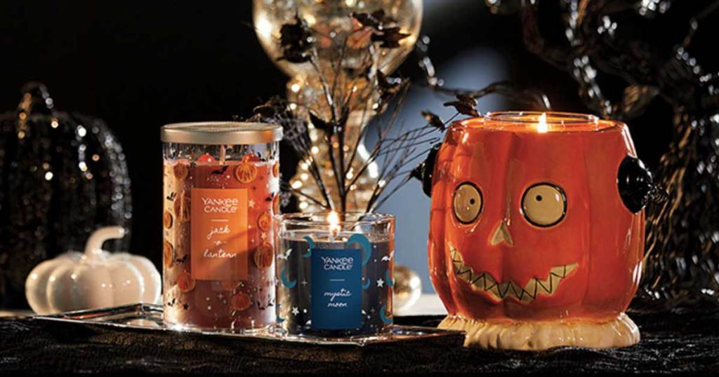 orange and blue halloween candles and a pumpkin candle holder