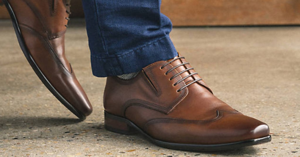 man wearing jeans and a pair of brown leather wingtip oxford shoes