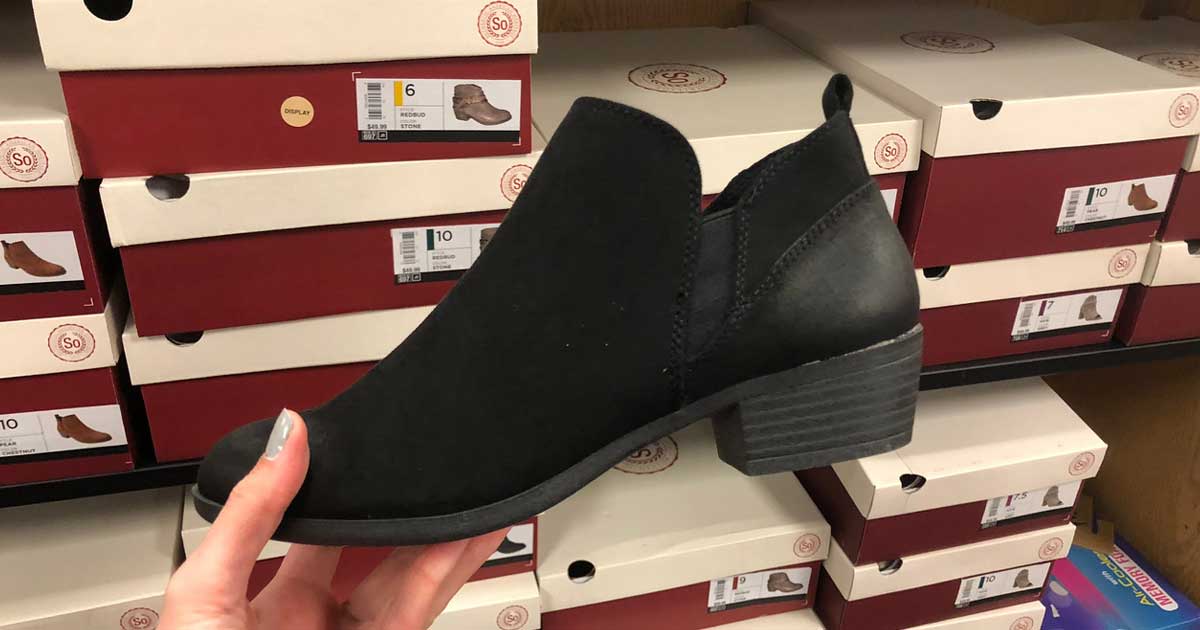 hand holding a black ankle boot in store