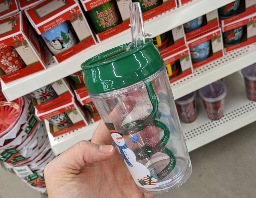 person holding up snowman printed kids tumbler with green swirly straw inside