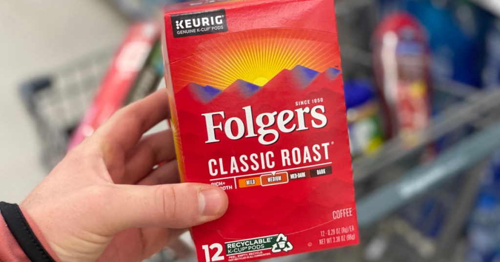 man's hand holding box of coffee pods in store