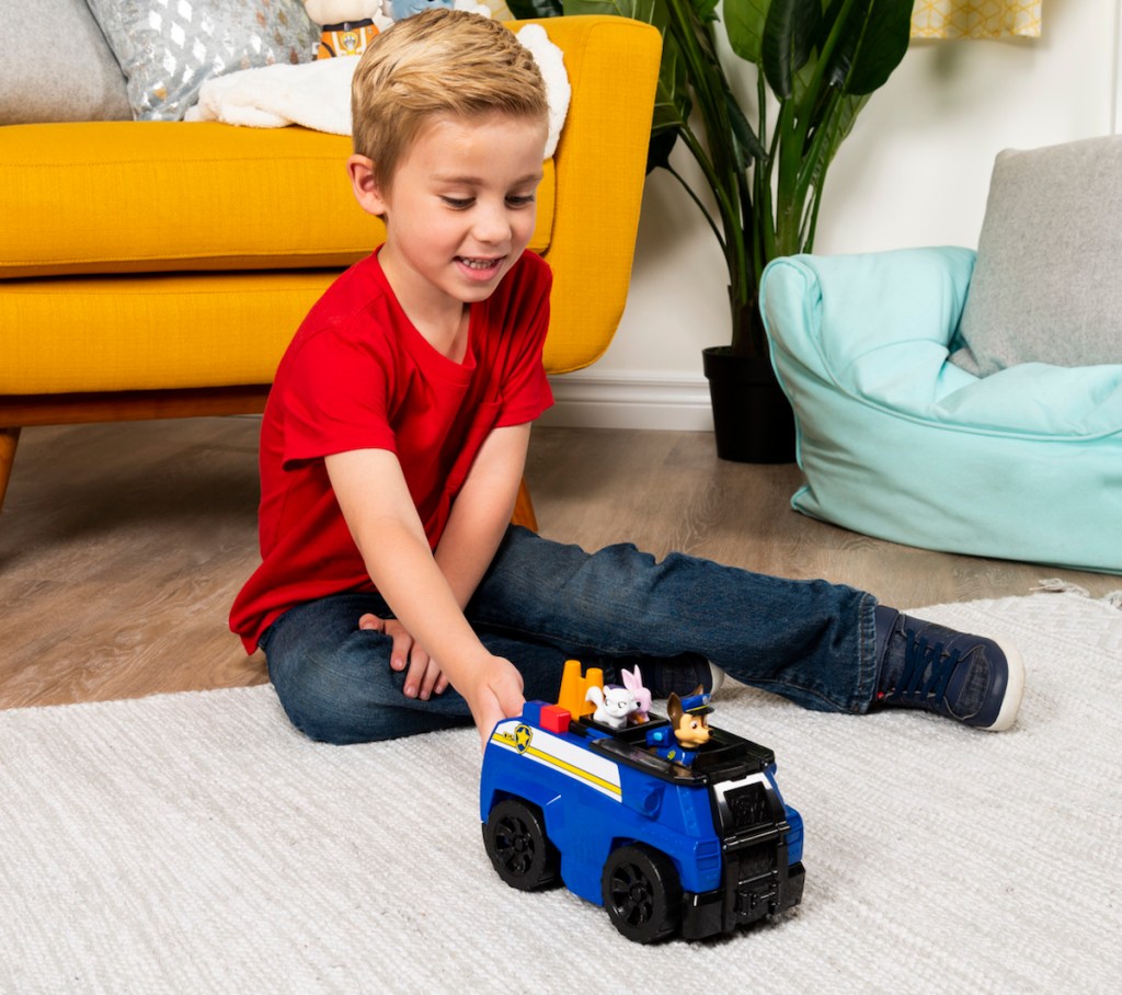 boy playing PAW Patrol Chase&rsquo;s Ride &lsquo;n&rsquo; Rescue Transforming 2-in-1 Playset and Police Cruiser