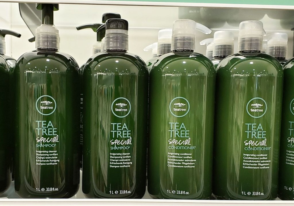 large green bottles of tea tree shampoo and conditioner on display shelf