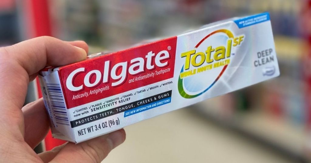 hand holding Colgate Total Toothpaste