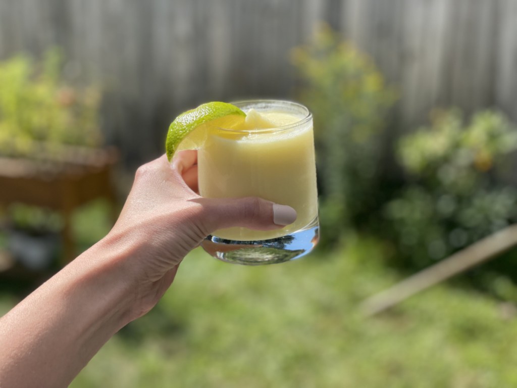 the best pi&ntilde;a colada recipe, holding a glass