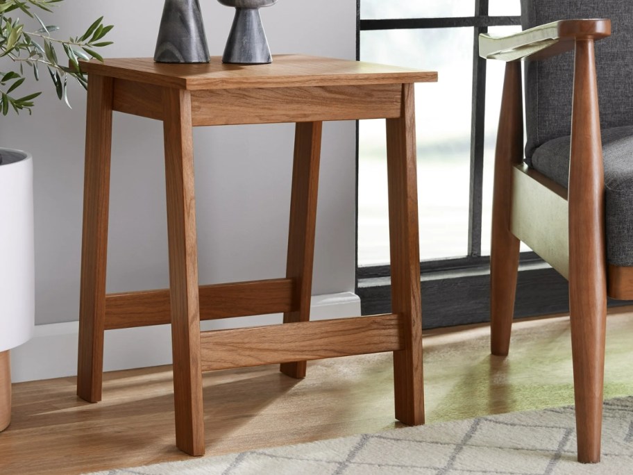 mainstays end table in walnut sitting next to accent chair with candles 