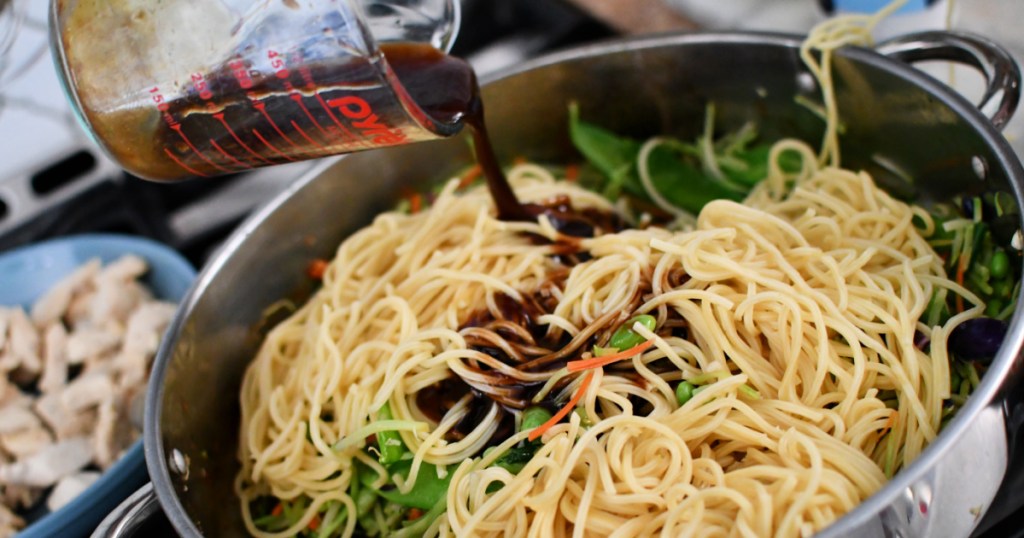 adding sauce to chow mein
