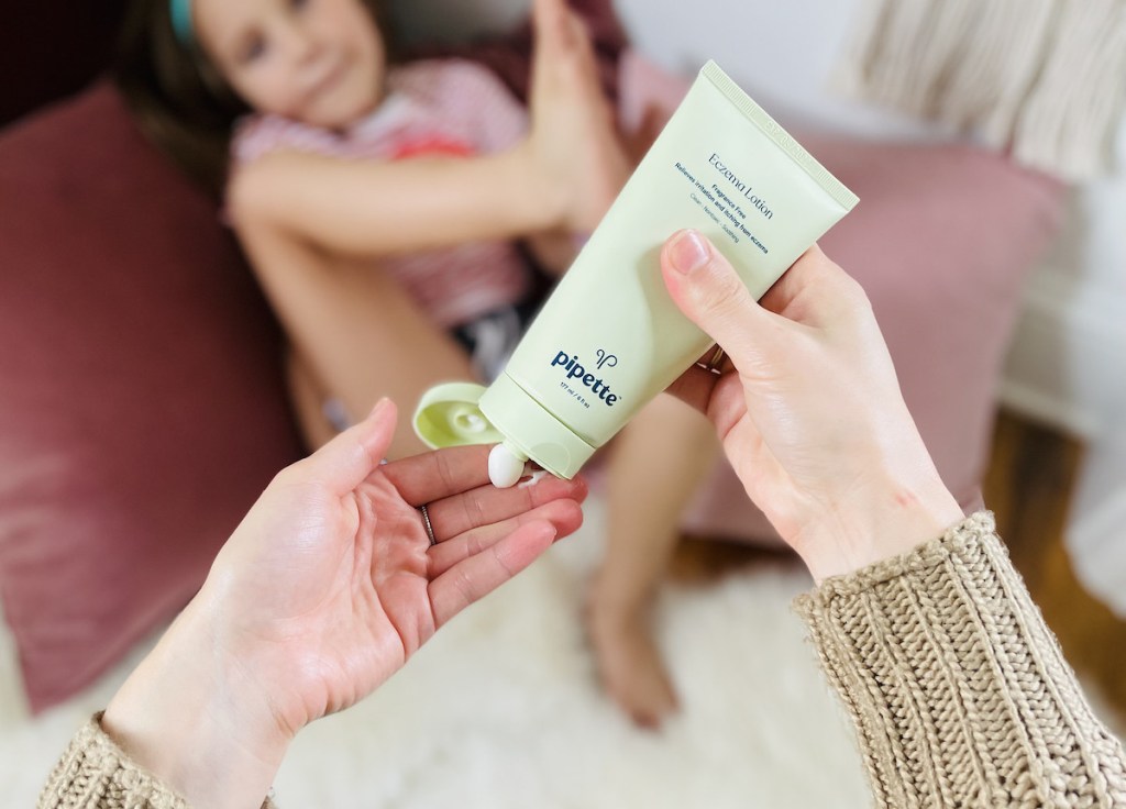 hands holding tube of eczema lotion