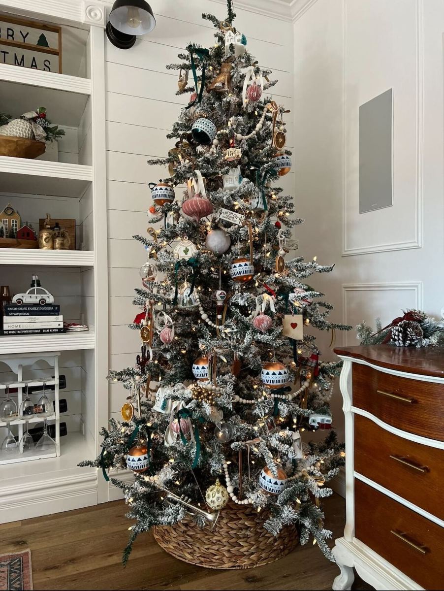 Flocked Christmas tree in corner of living room with white walls