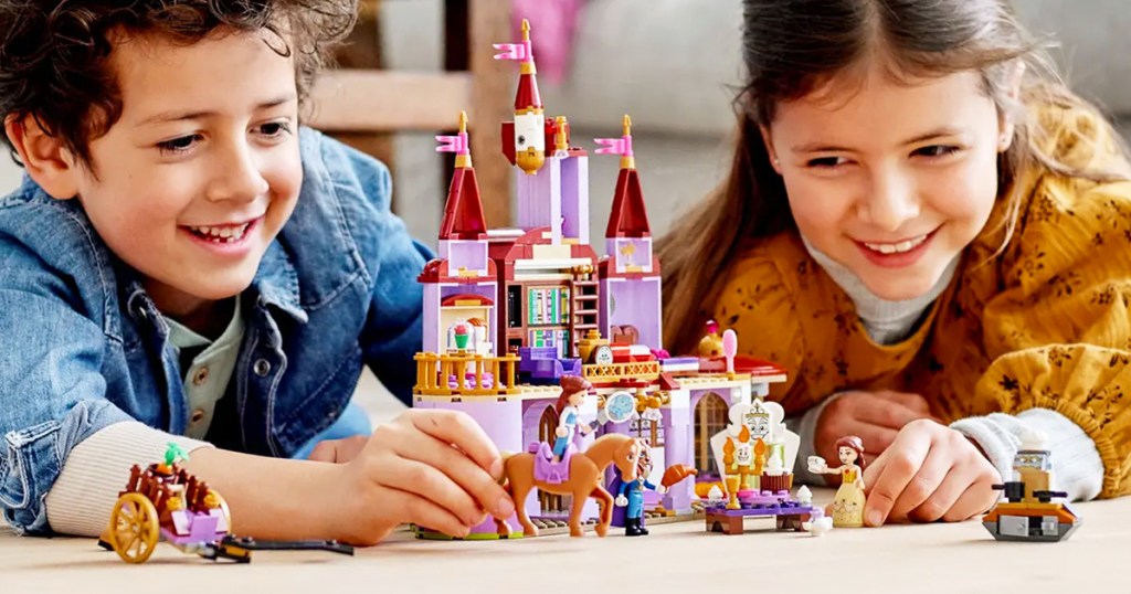 boy and girl playing with LEGO Disney Belle and the Beast&rsquo;s Castle set on floor