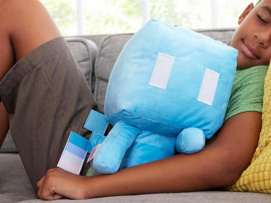 boy laying on couch with a blue Minecraft Plush Allay