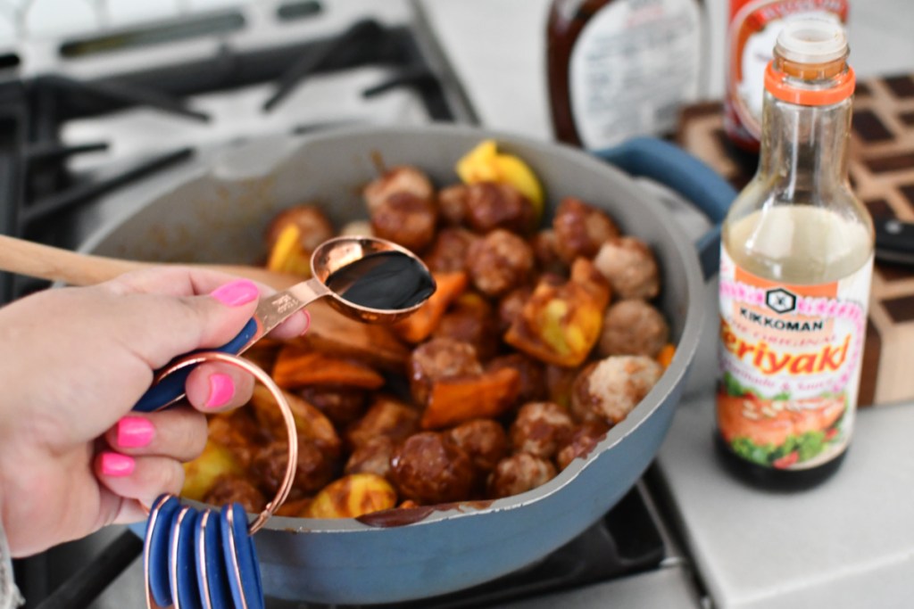adding teriyaki sauce to meatballs