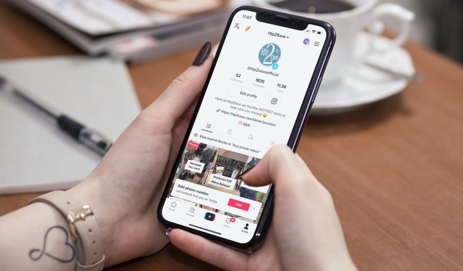 hand holding phone with hip2save tiktok account on screen