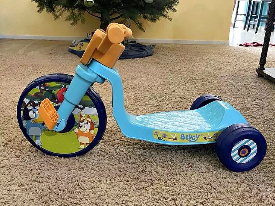 A Bluey trike on the floor.