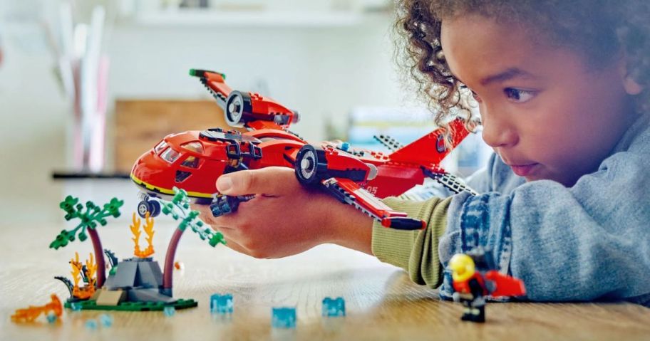 kid playing with LEGO City Fire Rescue Plane