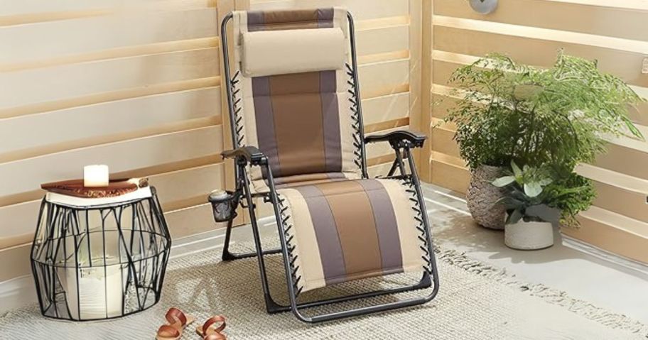 tri-colored zero gravity chair on patio next to plants and side table