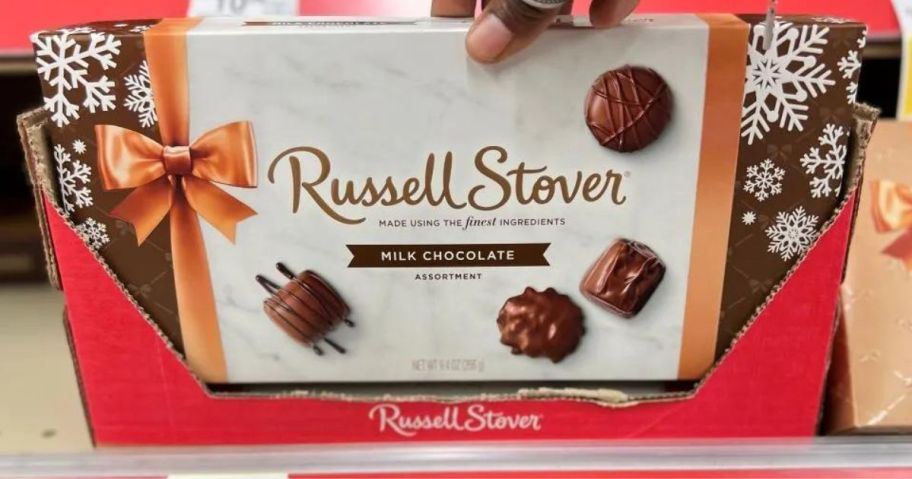hand grabbing a Russell Stover candy box 