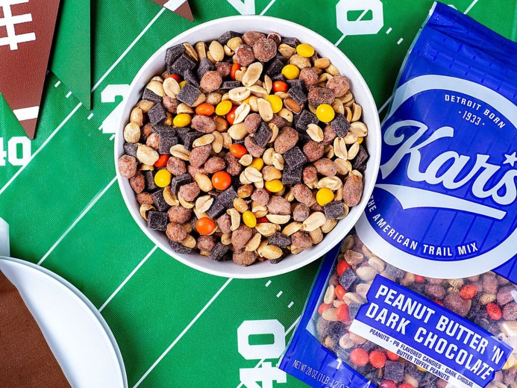 Kar's Nuts Peanut Butter &lsquo;n Dark Chocolate Trail Mix 2 in bowl and bag on football themed table cloth