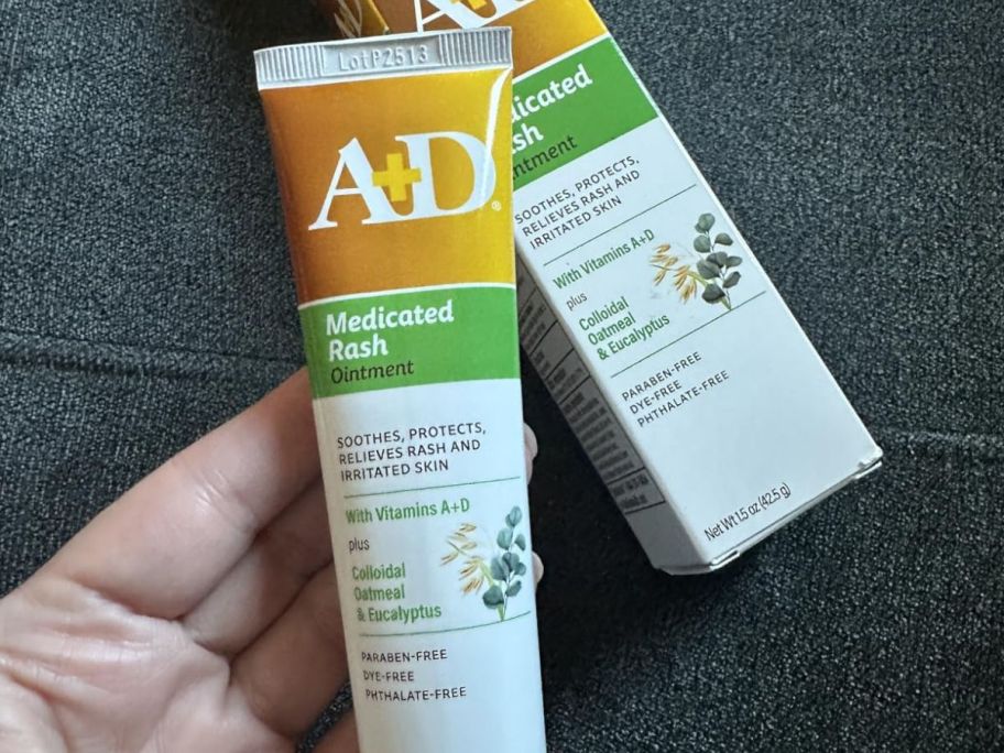 A persona holding A+D ointment in their hand