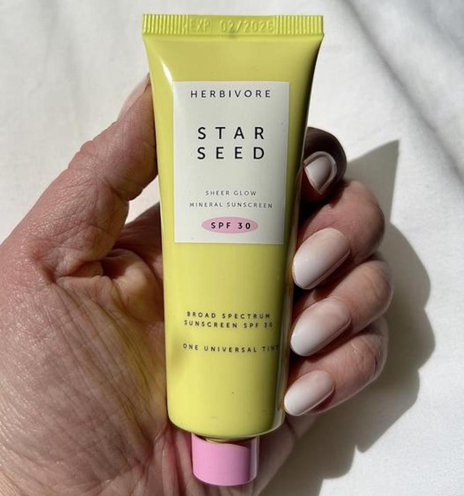 hand holding herbivore star seed mineral sunscreen