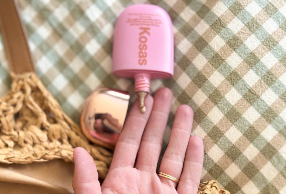 hand holding kosas dreambeam tinted makeup